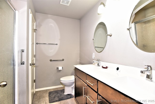 bathroom featuring tile patterned flooring, toilet, vanity, and walk in shower