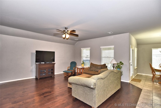 living room with dark wood-type flooring, ceiling fan, and vaulted ceiling