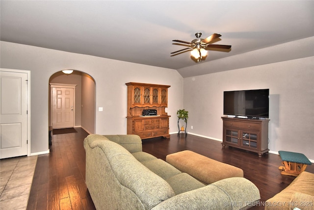 living room featuring vaulted ceiling, dark hardwood / wood-style floors, and ceiling fan