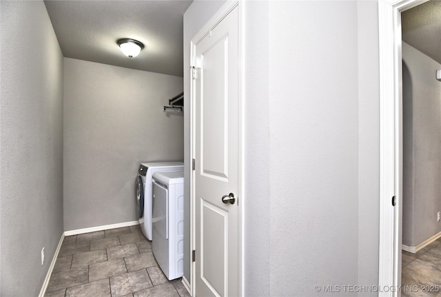 washroom featuring washer and clothes dryer and a textured ceiling