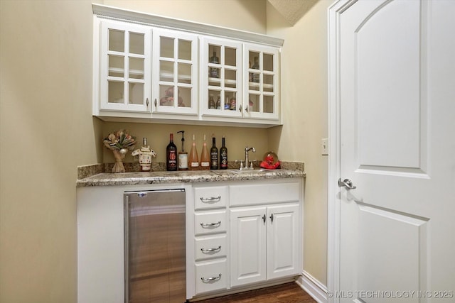 6215 E 86th Pl, Tulsa, OK 74137 - bar with wine cooler, sink, white cabinetry, and light stone countertops