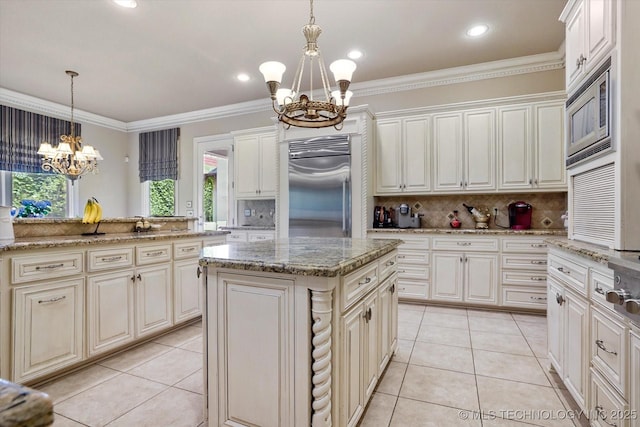 6215 E 86th Pl, Tulsa, OK 74137 - kitchen featuring built in appliances, a center island, hanging light fixtures, ornamental molding, and a notable chandelier