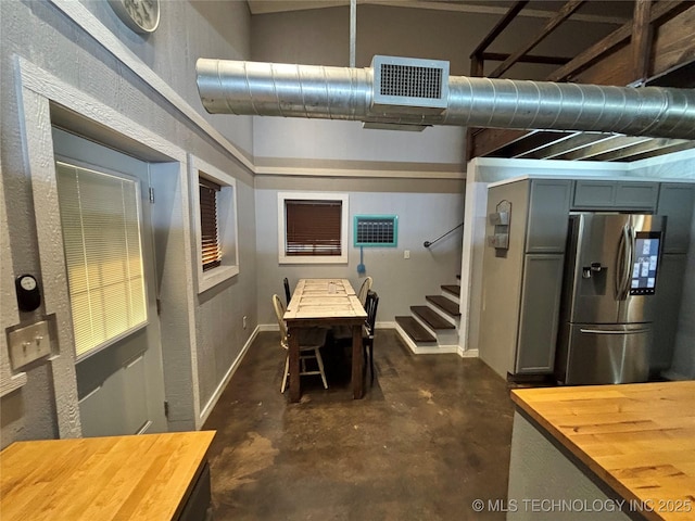 interior space with wood counters and stainless steel fridge with ice dispenser