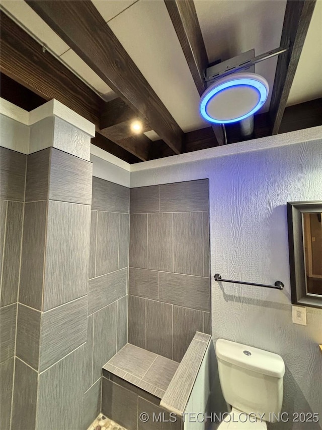 bathroom with beam ceiling and toilet