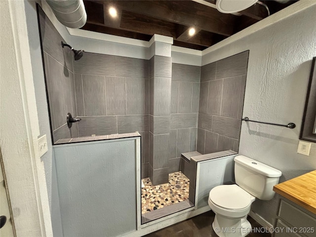 bathroom featuring tiled shower and toilet