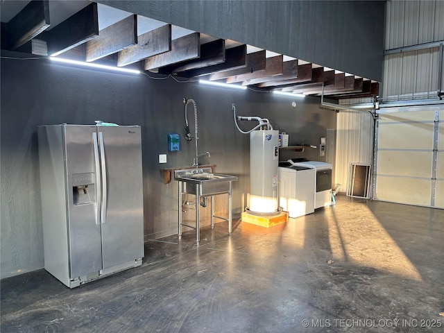 garage featuring stainless steel refrigerator with ice dispenser, washing machine and clothes dryer, sink, and electric water heater