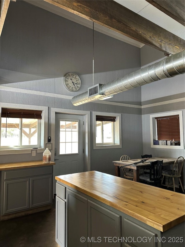 kitchen with gray cabinetry, butcher block countertops, beam ceiling, and high vaulted ceiling