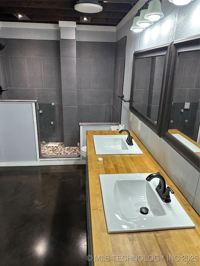 bathroom featuring vanity, toilet, and a tile shower