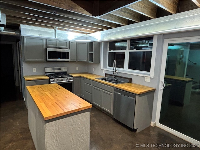 kitchen featuring stainless steel appliances, gray cabinets, butcher block counters, and sink