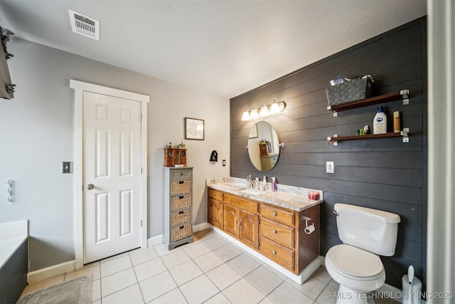 bathroom featuring tile patterned flooring, vanity, a bathing tub, and toilet