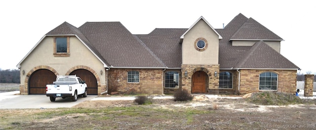 view of front of property with stucco siding, stone siding, driveway, and roof with shingles