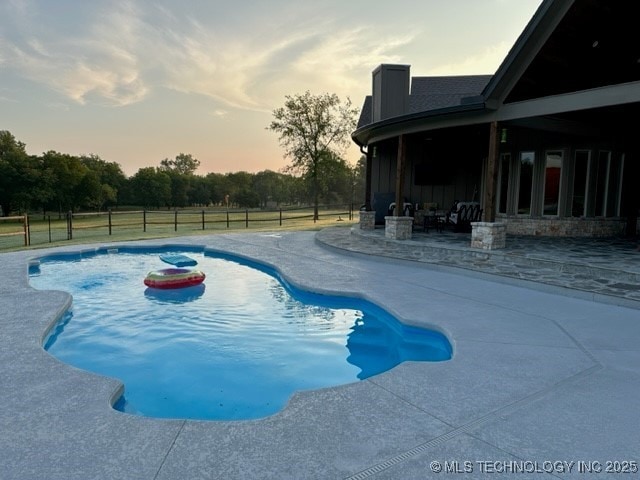 pool at dusk with a patio