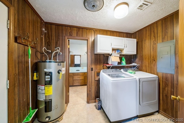 washroom with wooden walls, cabinets, electric panel, washing machine and dryer, and electric water heater