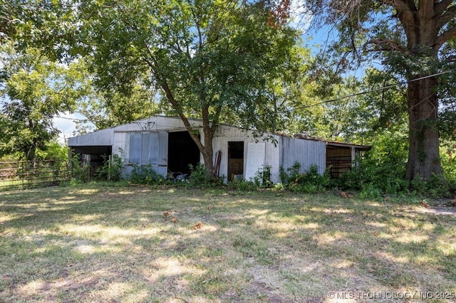 back of house with an outbuilding and a lawn