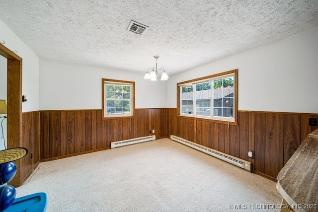 empty room featuring a baseboard radiator and wooden walls