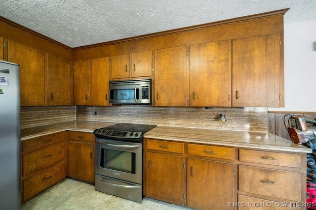 kitchen with tasteful backsplash, appliances with stainless steel finishes, and a textured ceiling