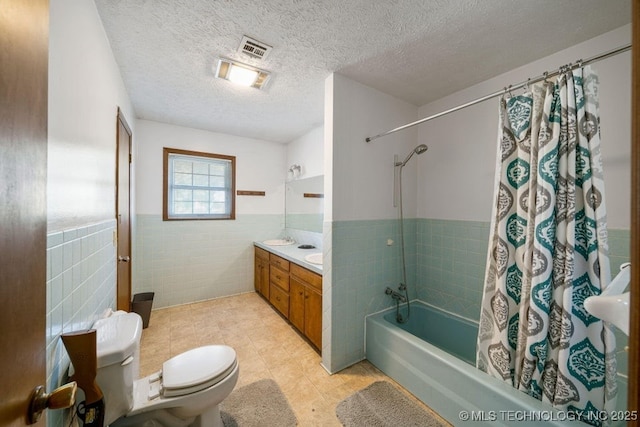 full bathroom with toilet, a textured ceiling, tile walls, vanity, and shower / bath combo