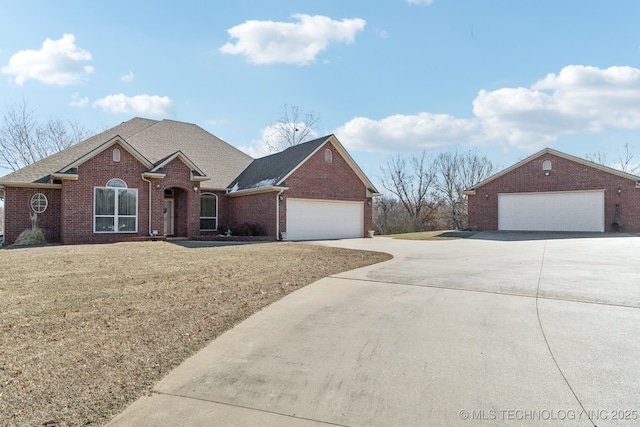 view of front of property with a garage, brick siding, a shingled roof, and a front lawn