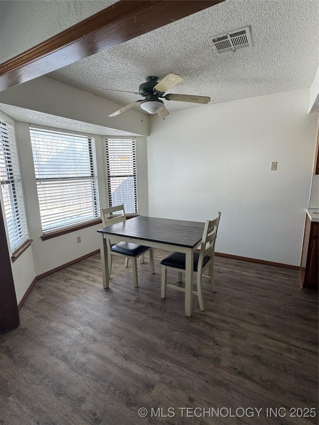 dining space featuring a textured ceiling, ceiling fan, and dark hardwood / wood-style floors