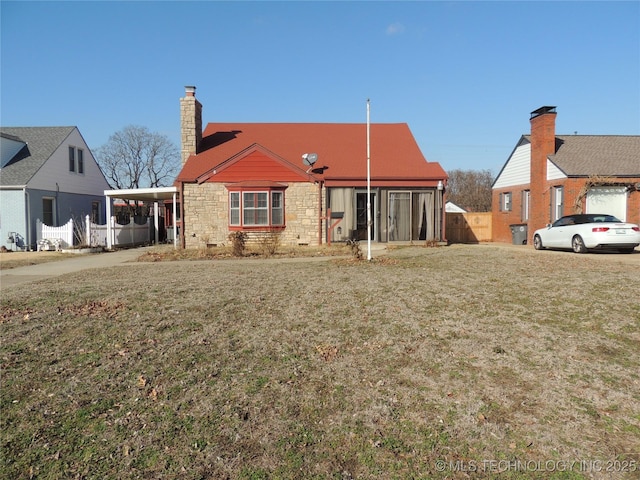 rear view of house with a carport and a yard