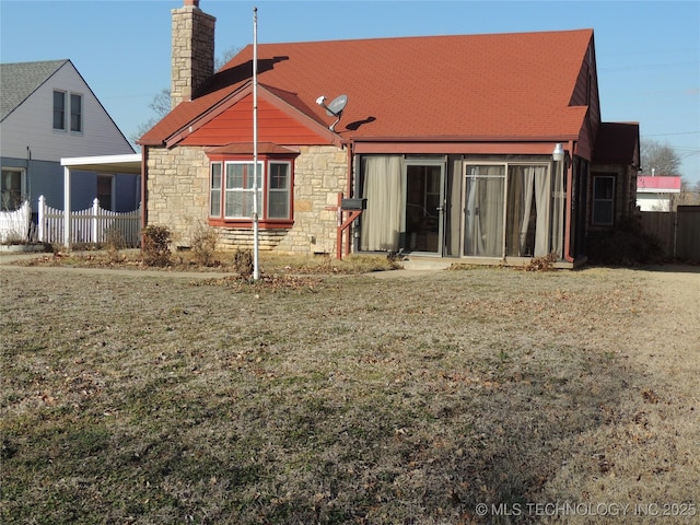 rear view of house featuring a lawn