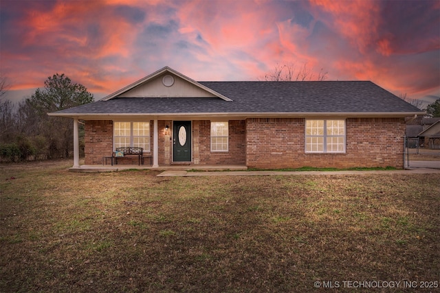 ranch-style house with a yard and covered porch