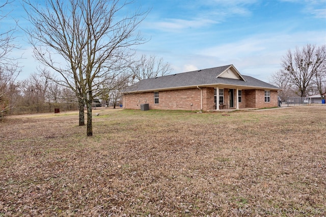 view of side of home with a yard and central AC unit