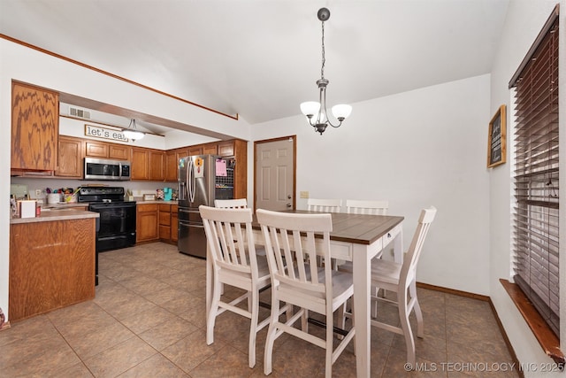 dining area featuring an inviting chandelier, light tile patterned floors, and vaulted ceiling