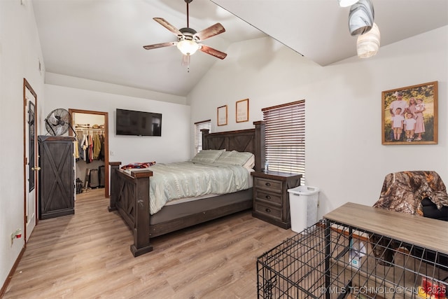 bedroom featuring a walk in closet, vaulted ceiling, light wood-type flooring, a closet, and ceiling fan