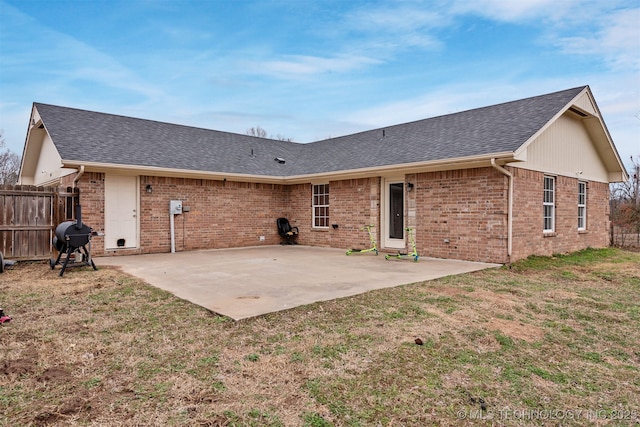 rear view of property with a patio and a lawn