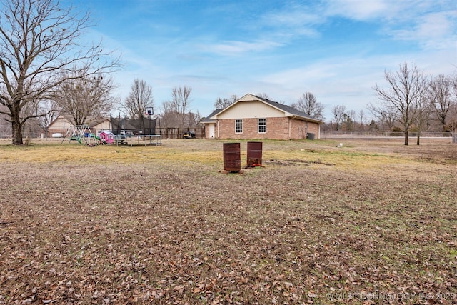 view of yard featuring a playground and a trampoline