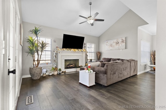 living room with a fireplace, dark wood-type flooring, ceiling fan, and vaulted ceiling