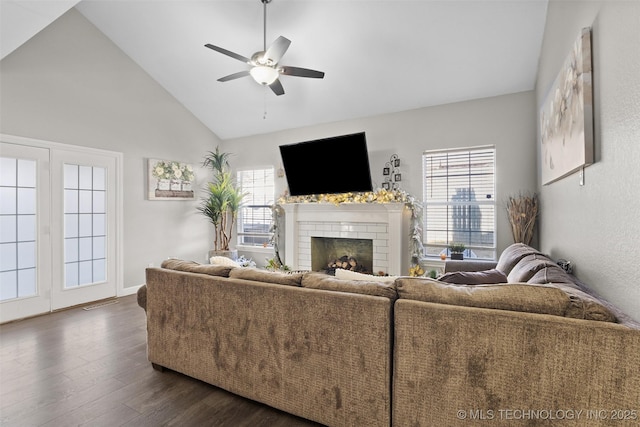 living room featuring dark wood-type flooring, ceiling fan, a fireplace, and high vaulted ceiling