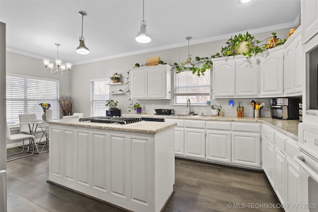 kitchen featuring white cabinetry, sink, decorative light fixtures, and stainless steel gas cooktop