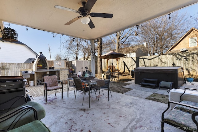 view of patio / terrace with ceiling fan, a hot tub, and exterior kitchen