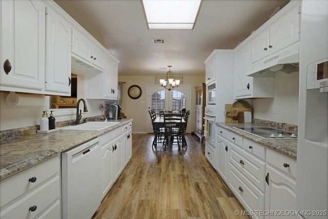 kitchen featuring pendant lighting, sink, white cabinets, light hardwood / wood-style floors, and white appliances