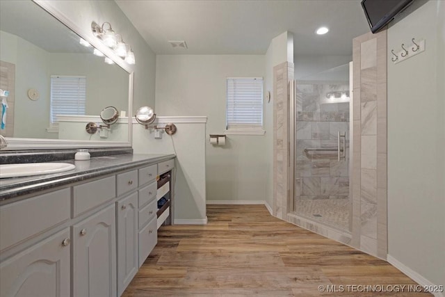 bathroom featuring walk in shower, wood-type flooring, and vanity