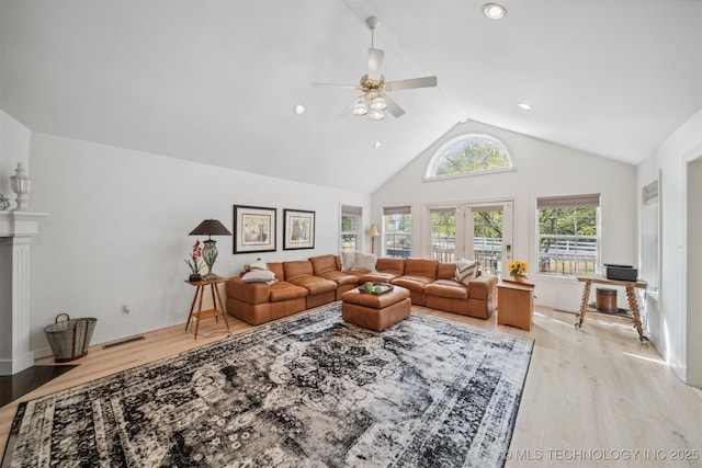 living room with ceiling fan, high vaulted ceiling, and light hardwood / wood-style floors