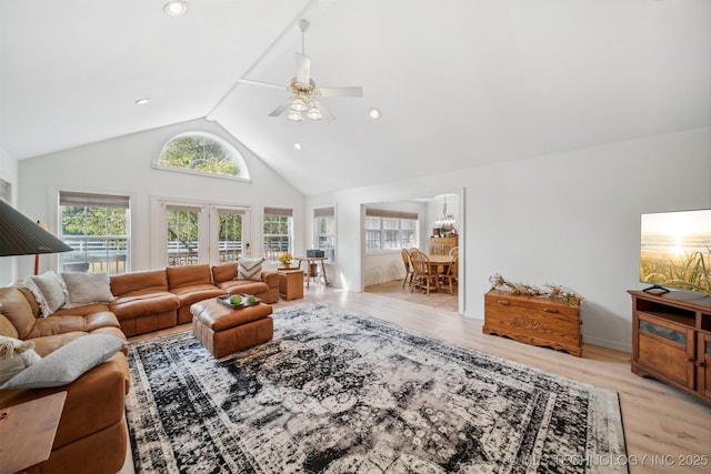 living room with high vaulted ceiling, ceiling fan, and light hardwood / wood-style flooring