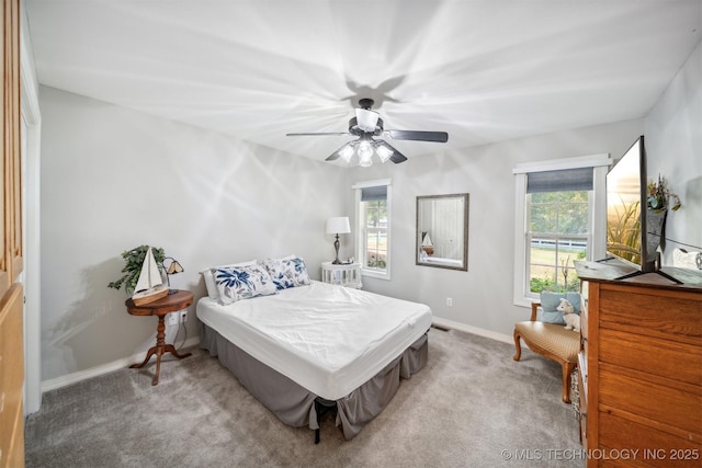 carpeted bedroom featuring ceiling fan and multiple windows