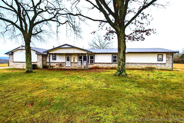 rear view of house with covered porch and a lawn