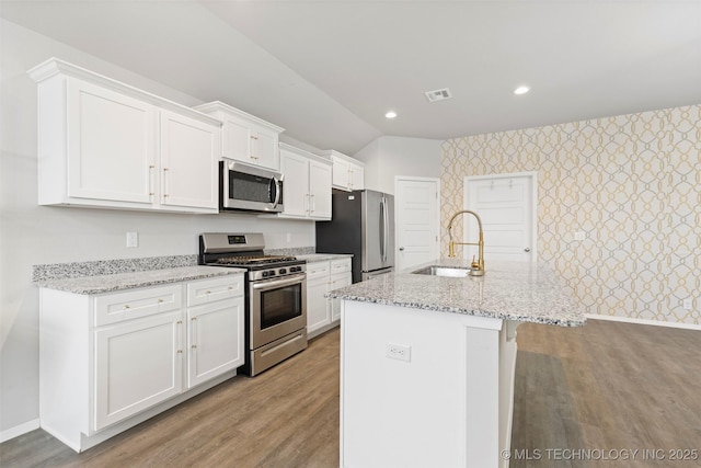 kitchen featuring white cabinetry, an island with sink, appliances with stainless steel finishes, and sink