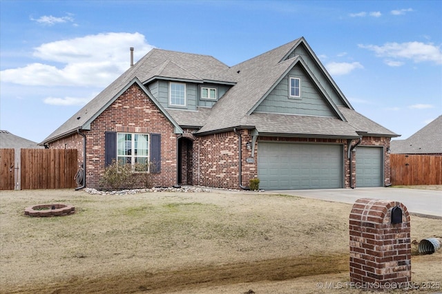 view of front of home featuring a garage, a front lawn, and an outdoor fire pit