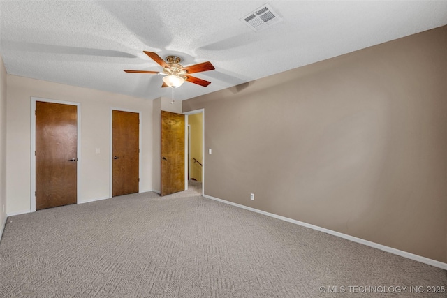 unfurnished bedroom with ceiling fan, carpet flooring, and a textured ceiling