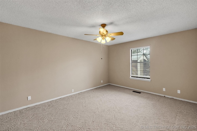 empty room with ceiling fan, carpet flooring, and a textured ceiling