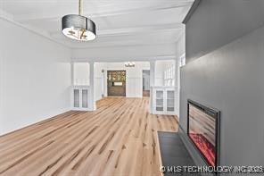 unfurnished living room featuring beam ceiling and light hardwood / wood-style flooring