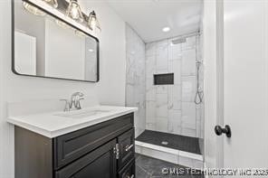 bathroom featuring vanity and tiled shower