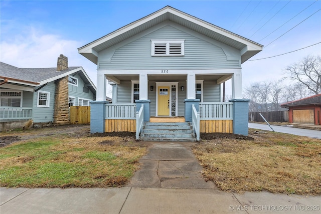 bungalow with covered porch and a front yard