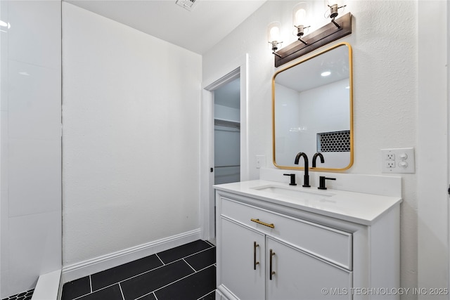 bathroom featuring vanity, tile patterned flooring, and a shower