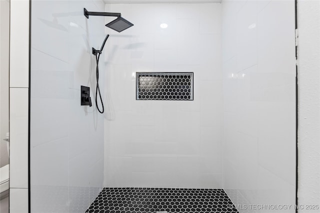 bathroom with toilet and tiled shower